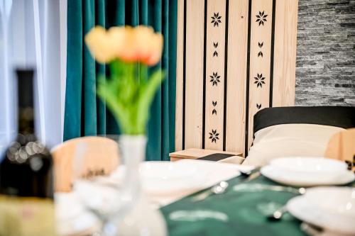 a table with a vase with a flower on it at Magiczny Domek in Białka Tatrzanska
