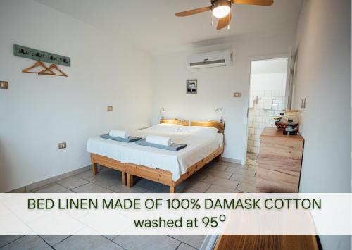 Ce lit se trouve dans une chambre blanche dotée d'un lit linéaire en davis. dans l'établissement Guesthouse Kamniti Rob, à Črni Kal