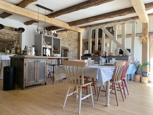 uma cozinha e sala de jantar com mesa e cadeiras em Agritourisme Abaé em Sougéal