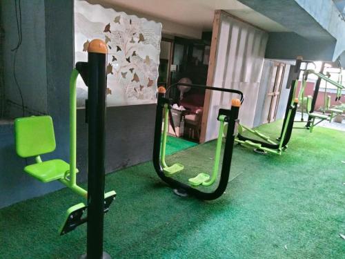 a group of green exercise bikes in a room at Hotel Serene Viman Nagar in Pune