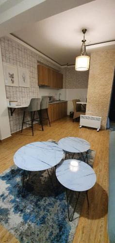 two tables in an empty room with a kitchen at Mujen Lux Kopaonik - Superior Apartman in Kopaonik