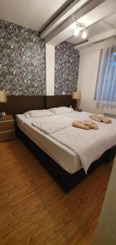a bedroom with a large bed with two towels on it at Mujen Lux Kopaonik - Superior Apartman in Kopaonik