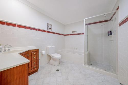 a bathroom with a shower and a toilet and a sink at Eastwood Central, Walk to Station & Shops, Drive to Olympic in Sydney