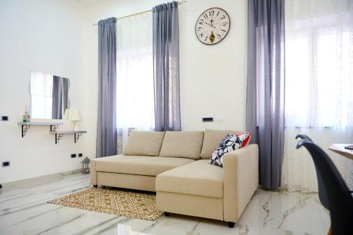 ein Wohnzimmer mit einem Sofa und einer Uhr an der Wand in der Unterkunft GG HOME in Saviano