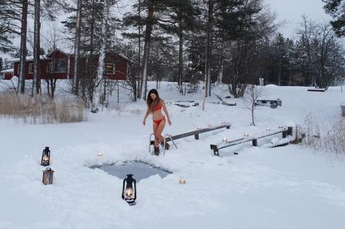 a woman walking through a puddle in the snow at Lapland Hygge in Rovaniemi