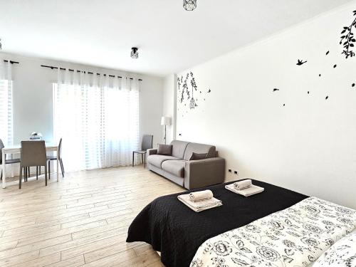 a white bedroom with a bed and a couch at Maremè Guest House Ostia in Lido di Ostia