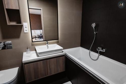 a bathroom with a sink and a tub and a toilet at AH Albelli II in Košice