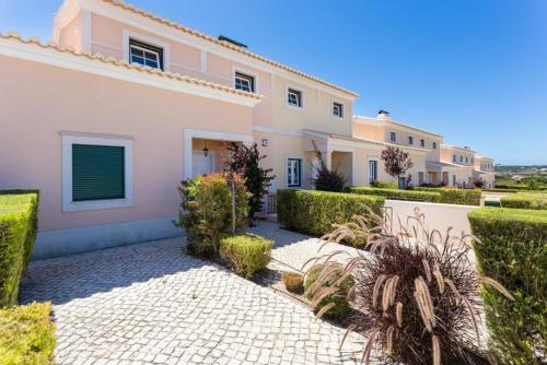 a large white house with bushes and a courtyard at Villa T3 com Jardim Vila Sagres M8 in Sagres