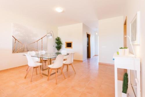 a dining room with a table and white chairs at Villa T3 com Jardim Vila Sagres M8 in Sagres
