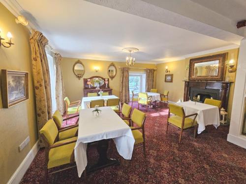 a dining room with two tables and yellow chairs at The Glenbeigh Hotel in Glenbeigh