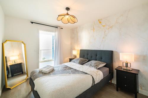 une chambre avec un grand lit et un miroir dans l'établissement 5mn Monaco - Terrasse - Vue mer - Parking - BD, à Beausoleil