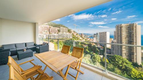 une pièce avec une table et des chaises sur un balcon dans l'établissement 5mn Monaco - Terrasse - Vue mer - Parking - BD, à Beausoleil