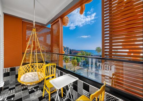 a balcony with yellow chairs and a swing at Anjeliq Downtown Boutique Hotel in Alanya
