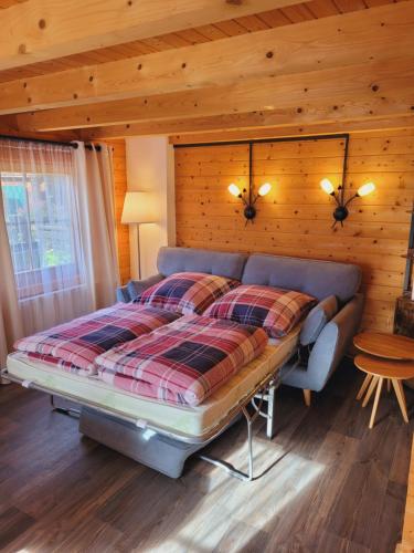 ein Schlafzimmer mit einem Bett und einer Holzwand in der Unterkunft Christinas Ferienhäuser in Rodewald in Neudorf