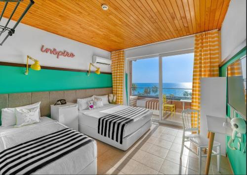 a bedroom with two beds and a balcony with the ocean at Anjeliq Downtown Boutique Hotel in Alanya