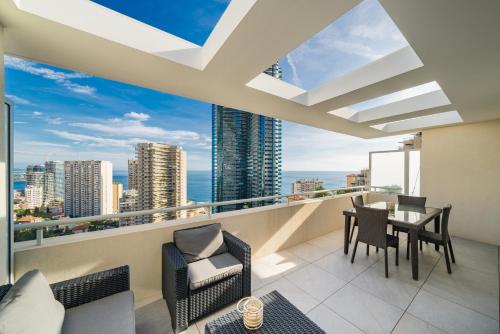 d'un balcon avec une table et des chaises offrant une vue sur la ville. dans l'établissement 5mn Monaco - Terrasse vue mer - Parking - BE, à Beausoleil