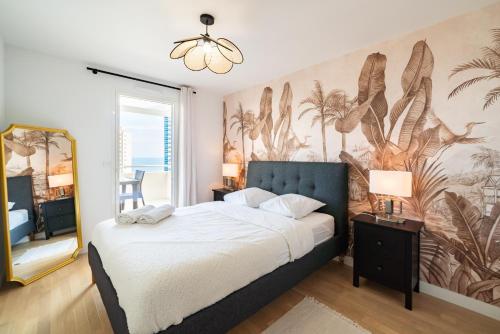 a bedroom with a bed and a wall with a mural at Large terrace, sea view, 5mn Monaco, free parking in Beausoleil
