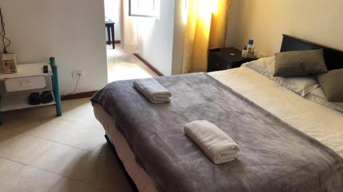 a bedroom with a large bed with two towels on it at ERY total confort Pasto apto in Pasto