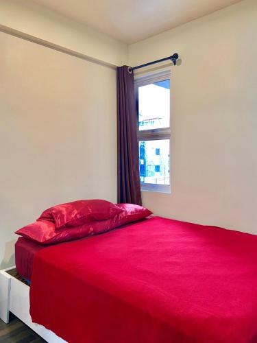 a bedroom with a red bed with a window at Resting View in Male City