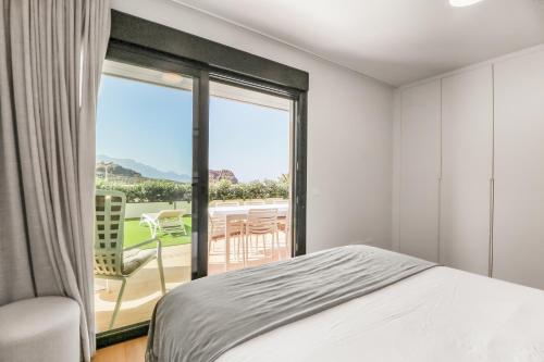 sypialnia z łóżkiem i dużym oknem w obiekcie Agaete 3BR Tropical Views w mieście Agaete