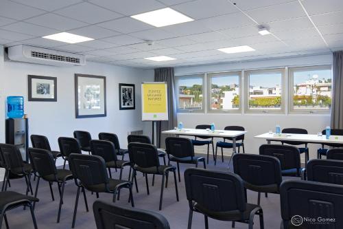 a conference room with tables and chairs and windows at ibis Styles Cannes Le Cannet in Cannes
