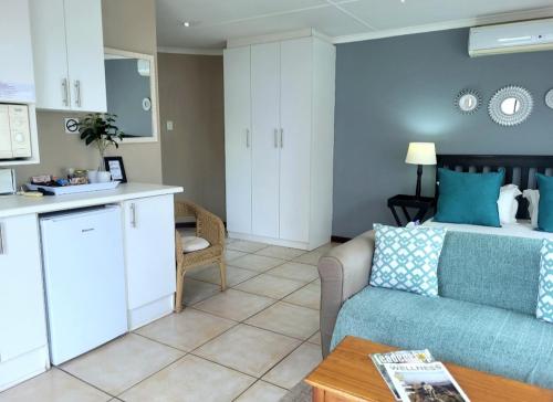 a living room with a couch and a kitchen at Suite 11- Deja' Blu Bed and Breakfast- East London in East London