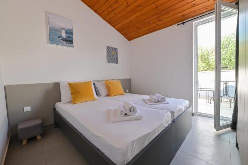 een slaapkamer met een groot bed met handdoeken erop bij Double L House in Novalja