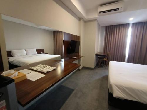 a hotel room with two beds and a desk at Studio4 in the heart of the city in Denpasar