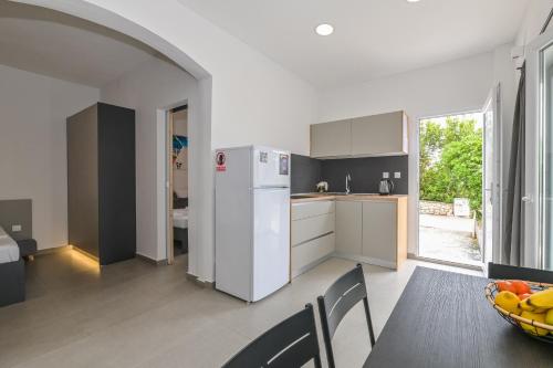 een keuken en eetkamer met een tafel en een koelkast bij Double L House in Novalja