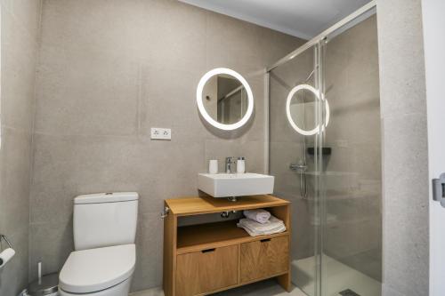 een badkamer met een toilet, een wastafel en een spiegel bij Agaete 2BR Coastal Retreat in Agaete