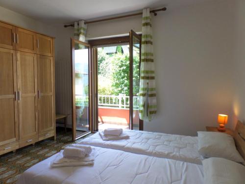 een slaapkamer met een groot bed en een glazen schuifdeur bij Ortensia in Baveno