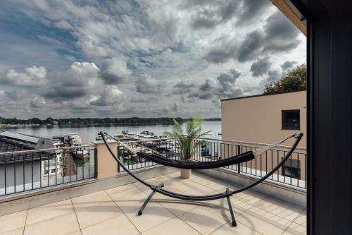 a hammock on a balcony with a view of the water at Exklusive Ferienwohnungen an der Havel in Werder