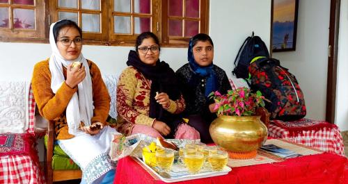 a group of three women sitting on a couch at Valley View Homestay in Darjeeling
