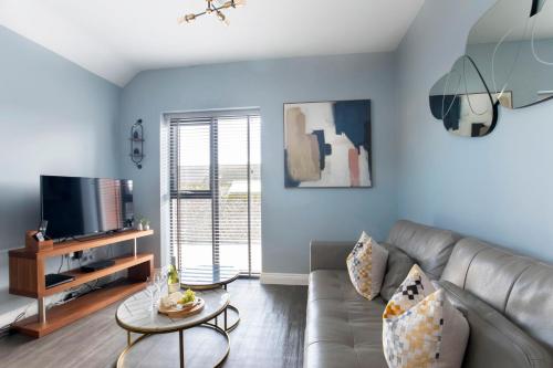 un soggiorno con divano e TV di Elliot Oliver - Luxurious Two Bedroom Apartment in The Docks a Gloucester