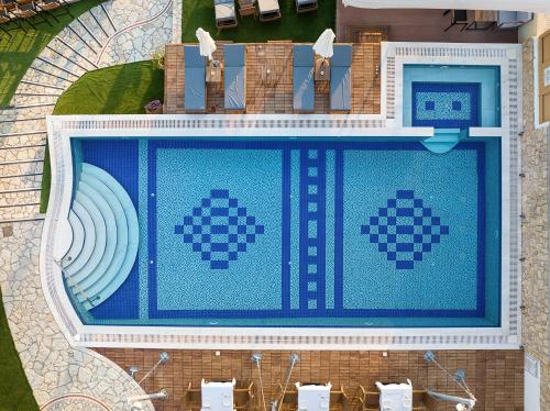 an overhead view of a swimming pool with blue tiles at Almira Hotel in Arkoudi