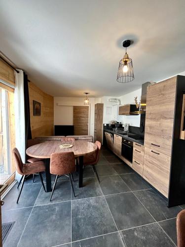 a kitchen with a table and chairs in a room at Appartement Valmeinier centre - Le Céleste in Valmeinier