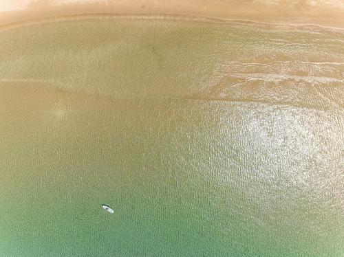 a boat in the water on a beach at Almira Hotel in Arkoudi