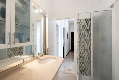 een badkamer met een wastafel en een glazen douche bij Il Corallo in Albisola Superiore