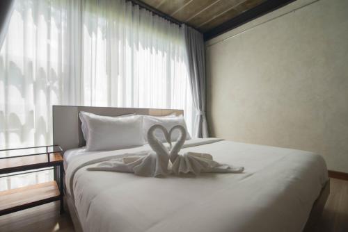 a white bed with a heart decoration on it at The Loft Bar365 in Buriram