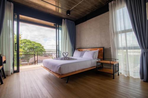 1 dormitorio con cama grande y ventana grande en The Loft Bar365, en Buriram