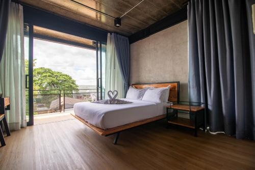 a bedroom with a bed and a large window at The Loft Bar365 in Buriram
