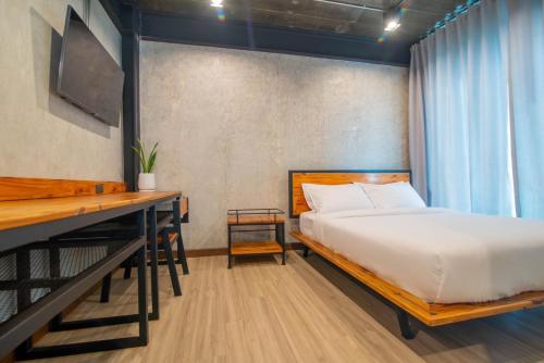 a bedroom with a bed and a desk at The Loft Bar365 in Buriram