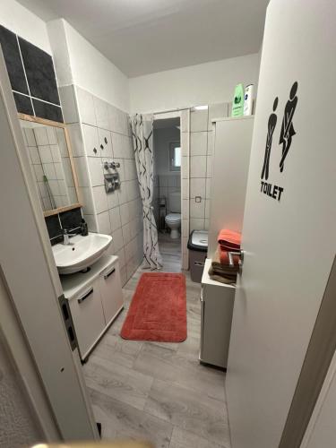 ein kleines Bad mit einem Waschbecken und einem WC in der Unterkunft Ferienwohnung in Sulzbach Nähe Augenklinik in Sulzbach