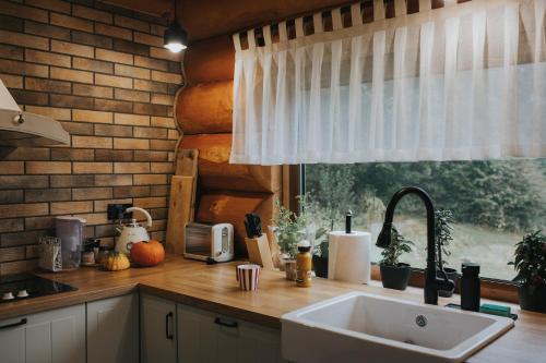 a kitchen counter with a sink and a window at Chata pod Olbrzymami in Zachełmie