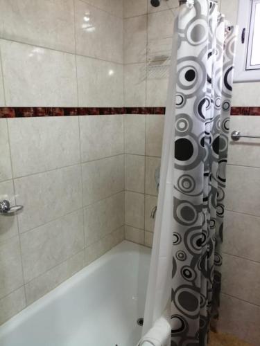 a shower with a black and white shower curtain at Rincón Bonito in El Hoyo