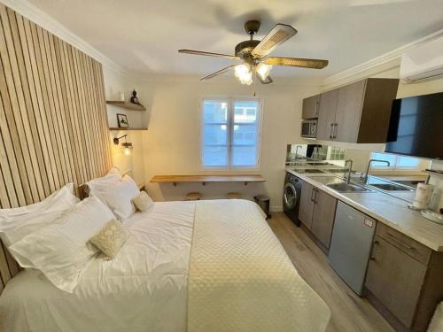 Cet appartement comprend une chambre avec un lit blanc et une cuisine. dans l'établissement Cozy Studio on Bd Croisette-AC- BeachesCongress by Olidesi, à Cannes