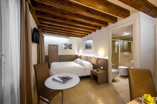 ヴェネツィアにあるLeone Hotelのベッドルーム1室(ベッド1台、テーブル付)、バスルーム1室が備わります。