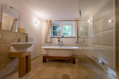 a bathroom with a white tub and a sink at Nengshof Ferienhäuser Sonnenblume und Heublume in Wißmannsdorf