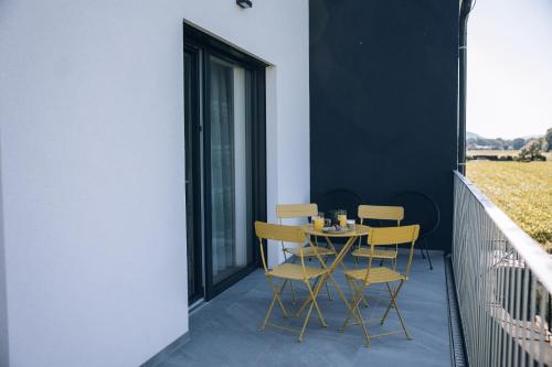 a table and chairs on the balcony of a house at Postcard Country Apartments in Spodnji Duplek