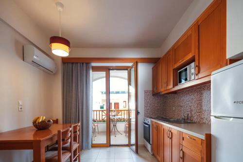 a kitchen with wooden cabinets and a table with a dining room at Aristea Hotel in Rethymno Town